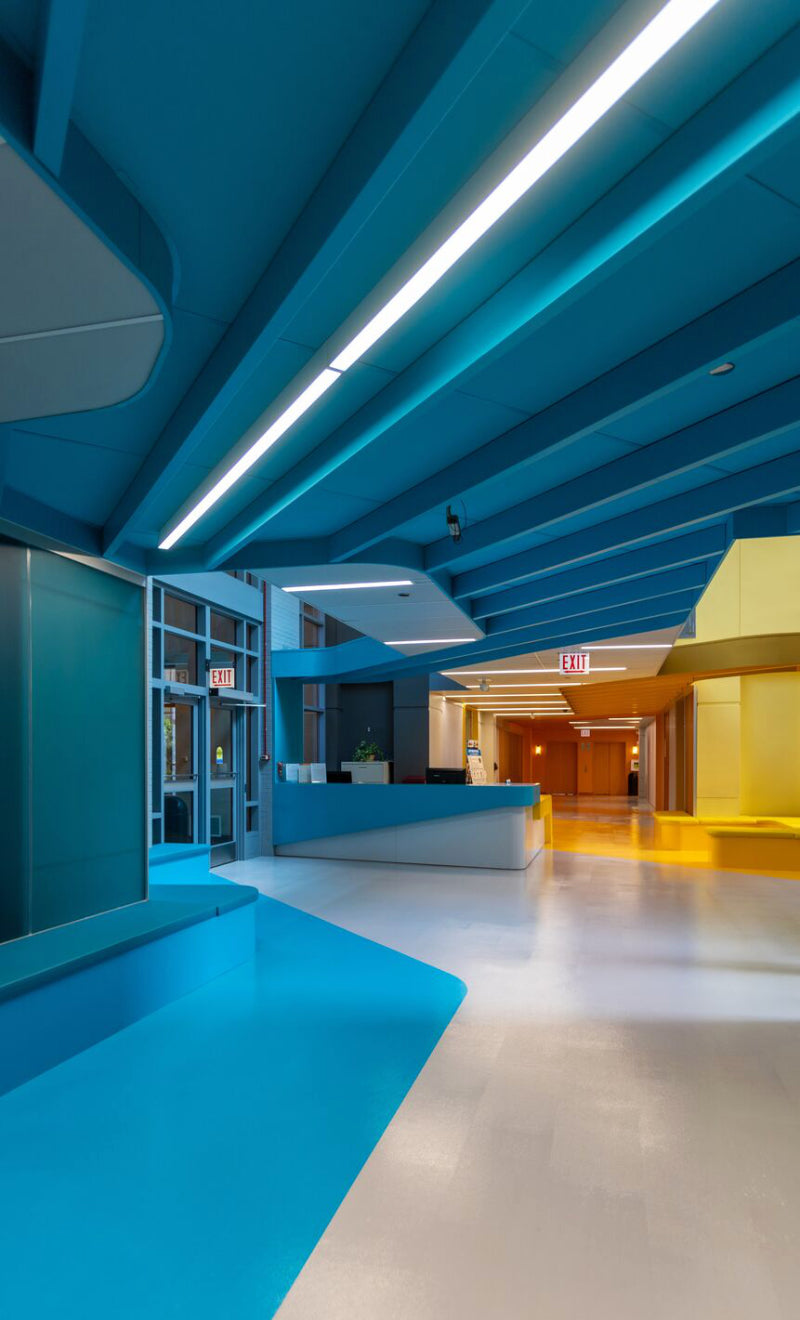Modern interior with blue ceiling panels and a reception desk.