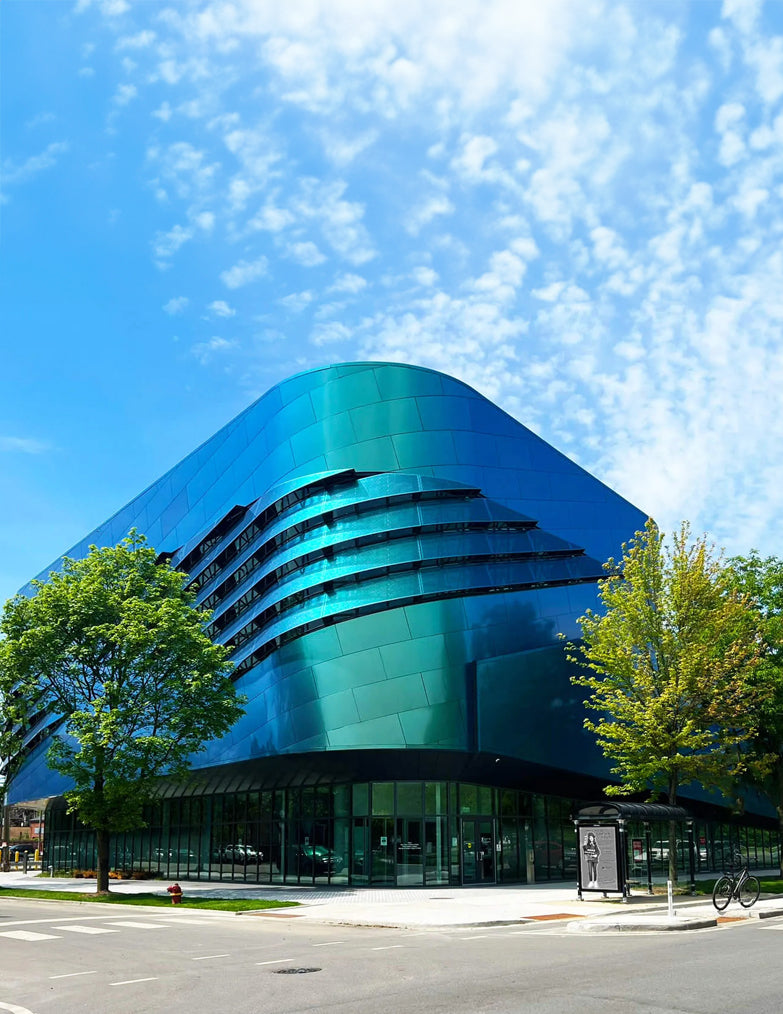 Modern building with a blue glass facade under a clear blue sky. Humboldt Park wellness center.